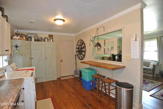 1307 Hunters Rd, New Bern, NC 28562 - kitchen featuring dark wood-style flooring, crown molding, a kitchen bar, white cabinets, and independent washer and dryer
