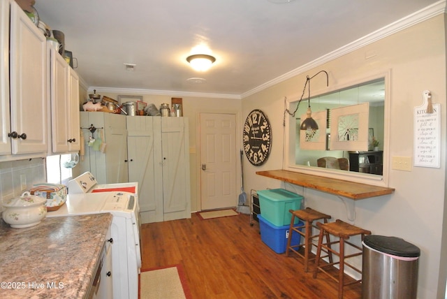 1307 Hunters Rd, New Bern, NC 28562 - kitchen featuring wood finished floors, ornamental molding, backsplash, a breakfast bar, and white cabinets