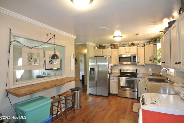 1307 Hunters Rd, New Bern, NC 28562 - kitchen featuring stainless steel appliances, ornamental molding, dark wood-style floors, tasteful backsplash, and a breakfast bar