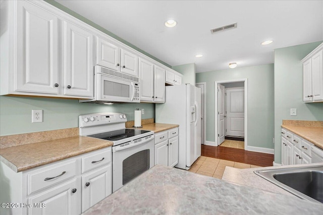 1009 Stonesthrow Ct, Leland, NC 28451 - kitchen featuring white appliances, white cabinets, light tile patterned flooring, light countertops, and recessed lighting