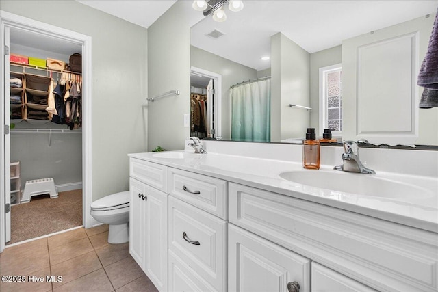 1009 Stonesthrow Ct, Leland, NC 28451 - bathroom with double vanity, a walk in closet, tile patterned floors, and a shower with curtain