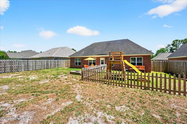 1009 Stonesthrow Ct, Leland, NC 28451 - back of property featuring a playground, a fenced backyard, and brick siding