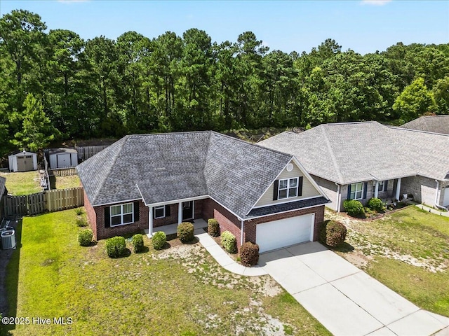 1009 Stonesthrow Ct, Leland, NC 28451 - view of front facade featuring driveway, a storage unit, brick siding, a garage, and a shingled roof