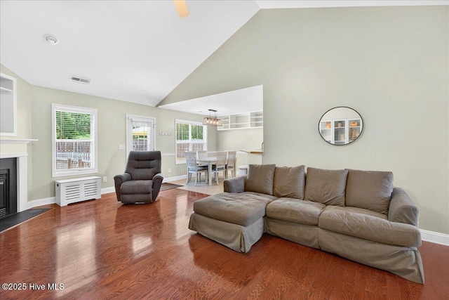 1009 Stonesthrow Ct, Leland, NC 28451 - living room with wood finished floors, a glass covered fireplace, a chandelier, and high vaulted ceiling