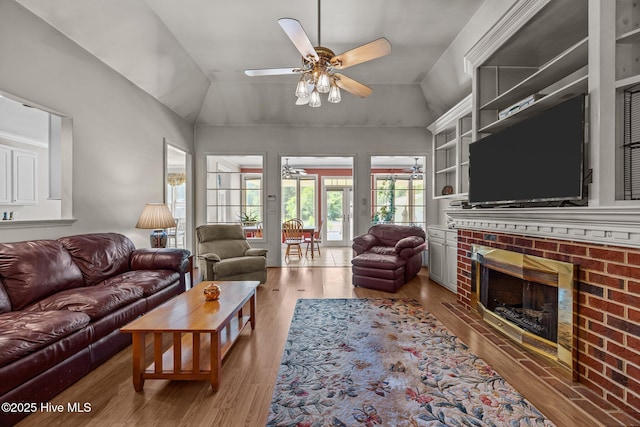 1910 Big Mill Rd, Williamston, NC 27892 - living area featuring a fireplace, ceiling fan, vaulted ceiling, and light wood-style flooring