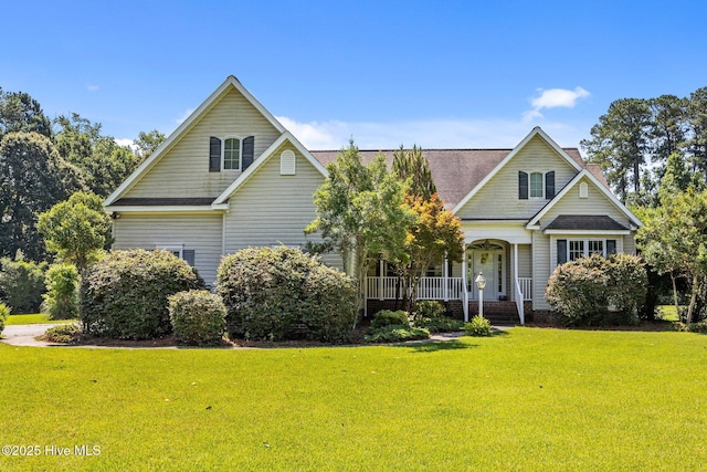 1910 Big Mill Rd, Williamston, NC 27892 - traditional home featuring a porch, a front lawn, roof with shingles, and a chimney