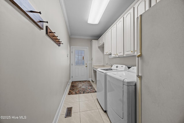 1910 Big Mill Rd, Williamston, NC 27892 - laundry area featuring washer and dryer, crown molding, cabinet space, and light tile patterned floors
