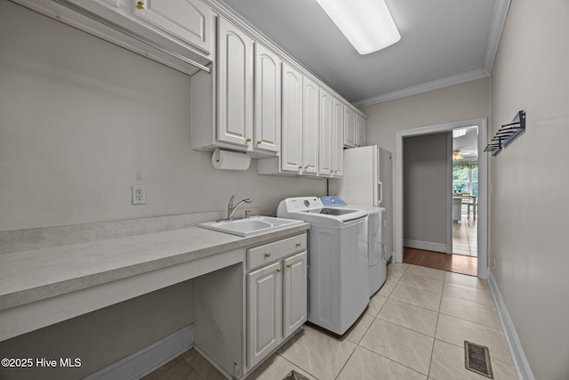 1910 Big Mill Rd, Williamston, NC 27892 - laundry room with washing machine and clothes dryer, ornamental molding, cabinet space, and light tile patterned floors