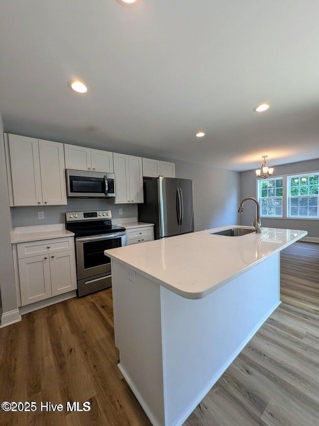 353 N Stephens St, Southern Pines, NC 28387 - kitchen with stainless steel appliances, a sink, dark wood-style floors, light countertops, and white cabinets