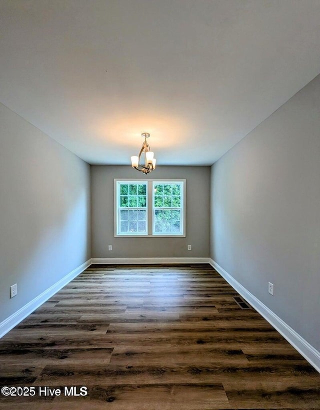 353 N Stephens St, Southern Pines, NC 28387 - empty room featuring a chandelier, dark wood-style floors, and baseboards