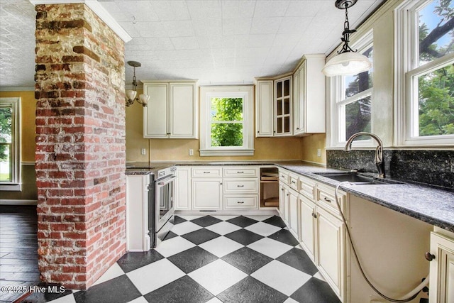 105 W Wayne St, Fremont, NC 27830 - kitchen featuring stainless steel range, cream cabinets, plenty of natural light, dark flooring, and ornamental molding