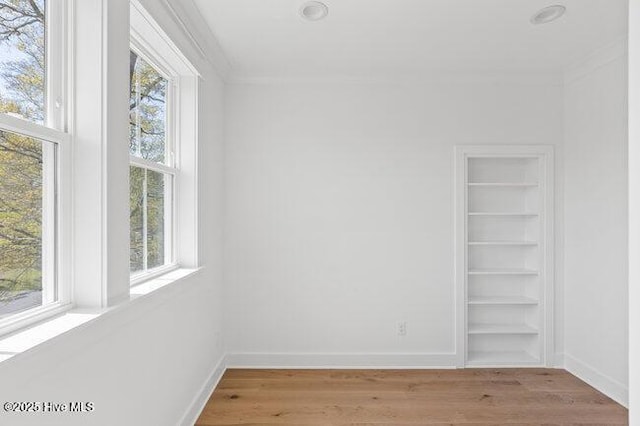 3404 Eagle Crest Dr SW, Supply, NC 28462 - unfurnished room with healthy amount of natural light, light wood-style flooring, built in features, and crown molding
