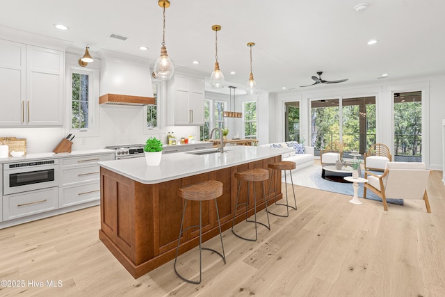 3404 Eagle Crest Dr SW, Supply, NC 28462 - kitchen featuring custom range hood, light countertops, a ceiling fan, an island with sink, and recessed lighting