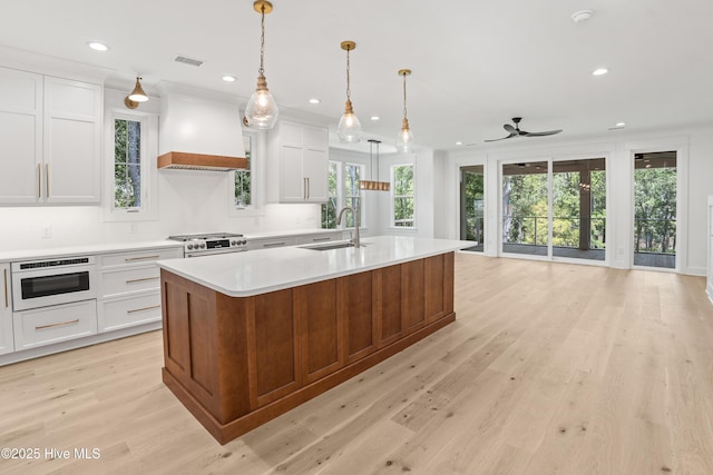 3404 Eagle Crest Dr SW, Supply, NC 28462 - kitchen with premium range hood, light countertops, light wood-style floors, a kitchen island with sink, and recessed lighting