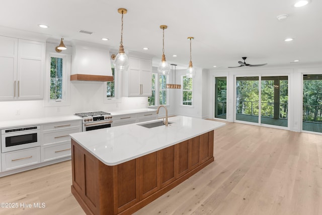 3404 Eagle Crest Dr SW, Supply, NC 28462 - kitchen featuring gas range oven, custom range hood, light countertops, a ceiling fan, and light wood finished floors