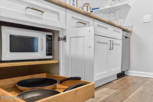 145 Royal Poste Rd # 3110, Sunset Beach, NC 28468 - kitchen view of white microwave, wood finished floors, and white cabinetry
