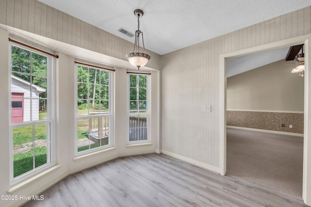 26 Combine Ln SE, Leland, NC 28451 - unfurnished dining area featuring wood finished floors, a textured ceiling, and wallpapered walls