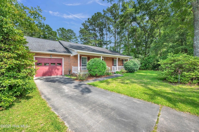 26 Combine Ln SE, Leland, NC 28451 - ranch-style house with covered porch, a garage, driveway, brick siding, and a front lawn