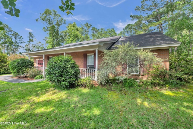 26 Combine Ln SE, Leland, NC 28451 - view of front facade featuring brick siding, a front yard, and covered porch