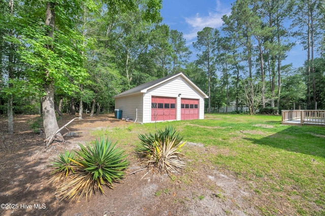 26 Combine Ln SE, Leland, NC 28451 - view of green lawn with a detached garage, an outdoor structure, view of wooded area, and a deck
