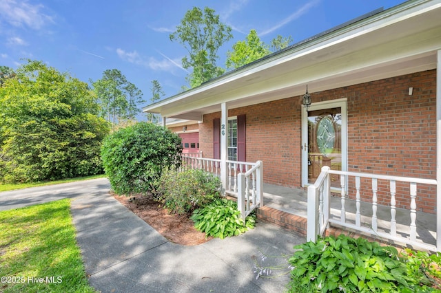 26 Combine Ln SE, Leland, NC 28451 - property entrance featuring a porch and brick siding