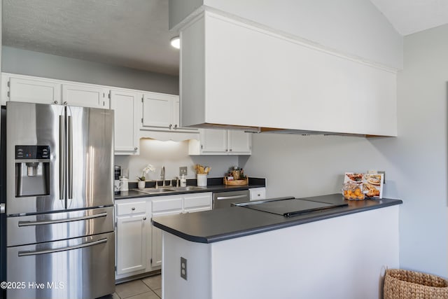 2418 Bradfield Ct, Wilmington, NC 28411 - kitchen with stainless steel appliances, dark countertops, white cabinetry, light tile patterned floors, and a peninsula