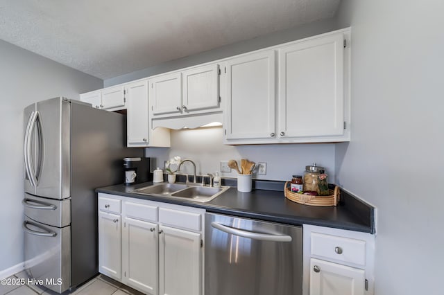 2418 Bradfield Ct, Wilmington, NC 28411 - kitchen featuring appliances with stainless steel finishes, dark countertops, white cabinetry, a textured ceiling, and light tile patterned flooring