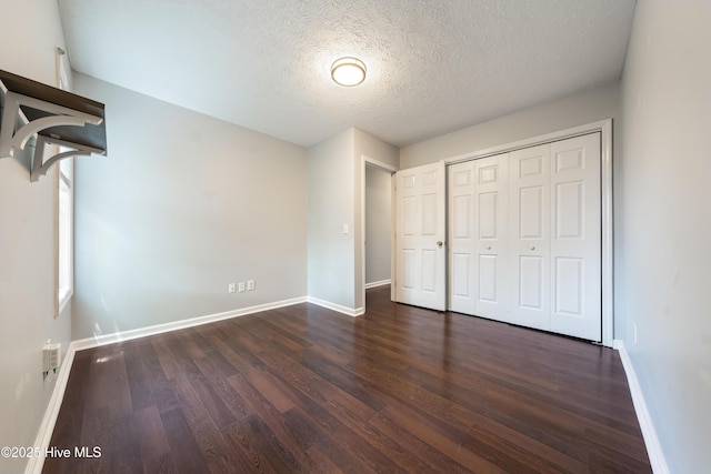 2418 Bradfield Ct, Wilmington, NC 28411 - unfurnished bedroom featuring dark wood finished floors, a textured ceiling, and a closet