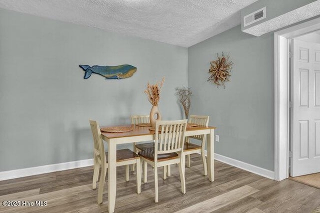 1701 Bowfin Ln Unit B, Carolina Beach, NC 28428 - dining area featuring wood finished floors and a textured ceiling