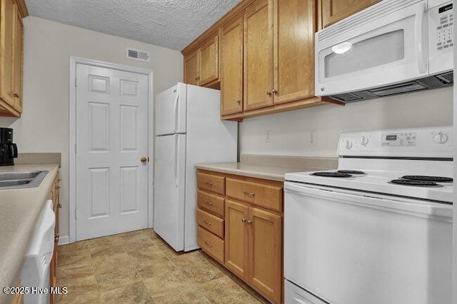 1701 Bowfin Ln Unit B, Carolina Beach, NC 28428 - kitchen with white appliances, light countertops, brown cabinets, stone finish floors, and a textured ceiling