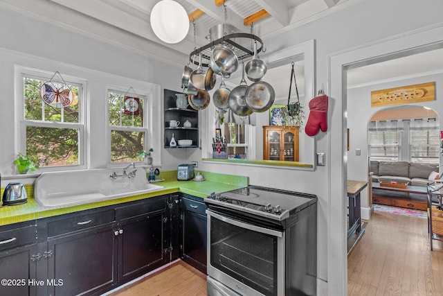 2018 Perry Ave, Wilmington, NC 28403 - kitchen with stainless steel electric range oven, beamed ceiling, light wood finished floors, dark cabinets, and light countertops