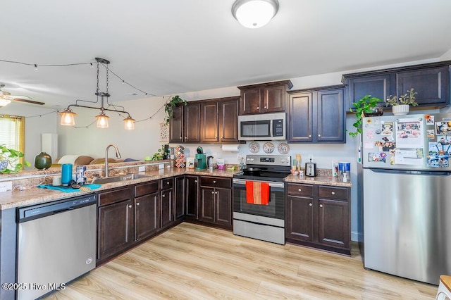 110 Meadow Way, Havelock, NC 28532 - kitchen featuring appliances with stainless steel finishes, light stone counters, dark brown cabinets, and light wood-style floors