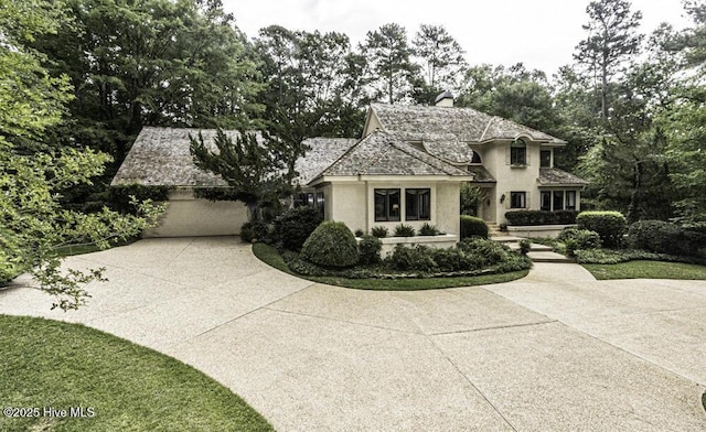 129 Steeplechase Rd, Rocky Mount, NC 27804 - french country inspired facade featuring concrete driveway, a chimney, a garage, and stucco siding