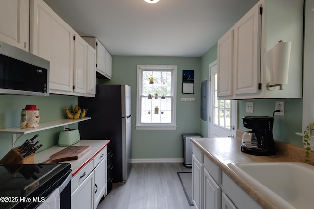 766 Swan Point Rd, Washington, NC 27889 - kitchen with appliances with stainless steel finishes, light wood-type flooring, white cabinetry, and light countertops