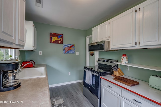 766 Swan Point Rd, Washington, NC 27889 - kitchen with appliances with stainless steel finishes, light countertops, dark wood-style flooring, and white cabinets