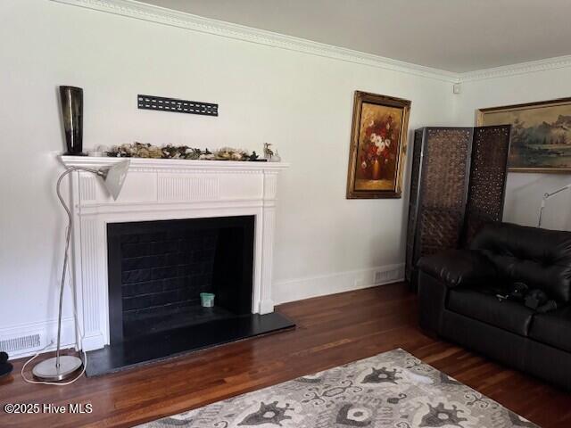621 W Hayes St, Ahoskie, NC 27910 - living area with wood finished floors, a fireplace with raised hearth, and ornamental molding