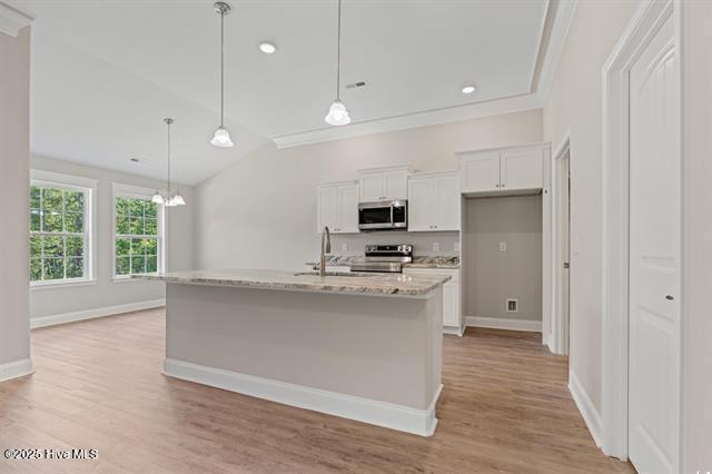 414 Laurel Ct NW, Calabash, NC 28467 - kitchen featuring stainless steel appliances, white cabinetry, light wood-type flooring, a chandelier, and lofted ceiling