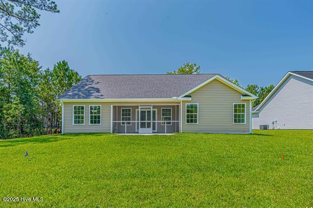 414 Laurel Ct NW, Calabash, NC 28467 - rear view of property with a lawn and a sunroom