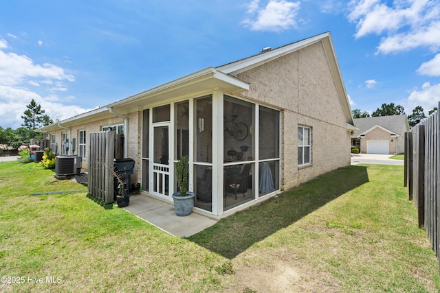 1067 Tideline Dr, Leland, NC 28451 - rear view of property with a sunroom, a lawn, and brick siding