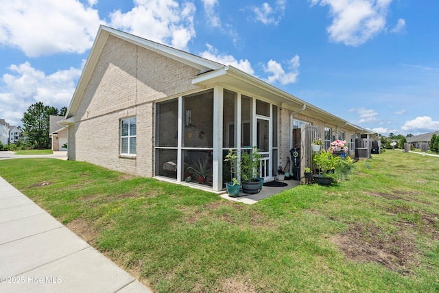 1067 Tideline Dr, Leland, NC 28451 - view of side of property featuring a sunroom, brick siding, and a lawn
