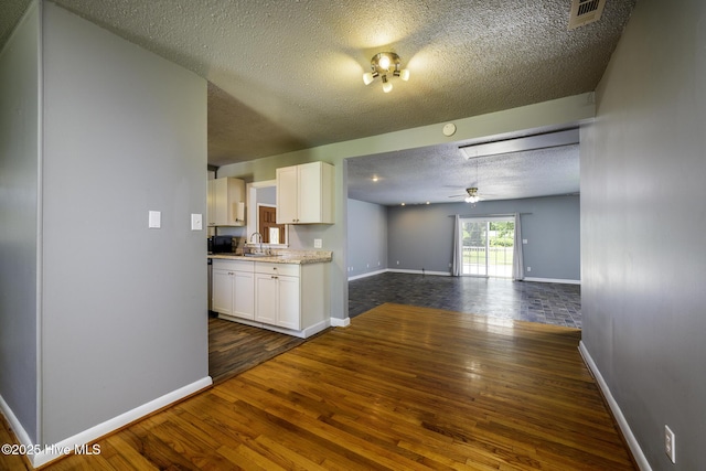 103 Elizabeth St, Havelock, NC 28532 - kitchen featuring dark wood-style flooring, a textured ceiling, white cabinets, a ceiling fan, and open floor plan