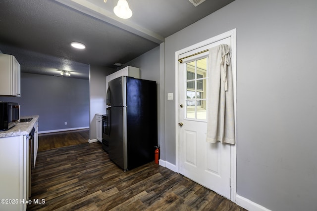 103 Elizabeth St, Havelock, NC 28532 - kitchen featuring freestanding refrigerator, white cabinets, dark wood finished floors, and light countertops