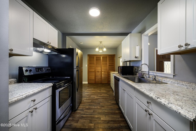 103 Elizabeth St, Havelock, NC 28532 - kitchen with appliances with stainless steel finishes, under cabinet range hood, dark wood-style flooring, white cabinets, and a textured ceiling