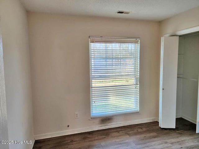 2823 Harvest, Grimesland, NC 27837 - unfurnished bedroom featuring wood finished floors, multiple windows, and a closet