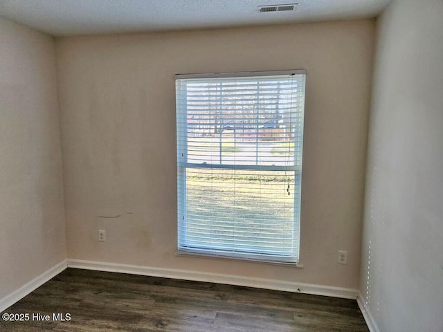 2823 Harvest, Grimesland, NC 27837 - spare room with plenty of natural light and dark wood finished floors