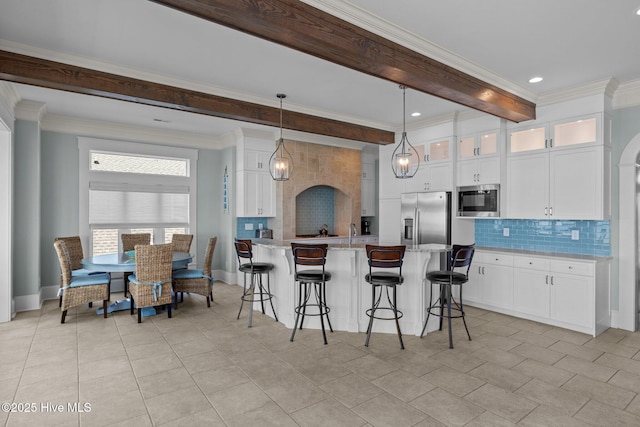 4101 Ocean Dr, Emerald Isle, NC 28594 - kitchen featuring stainless steel appliances, tasteful backsplash, a kitchen bar, beam ceiling, and crown molding