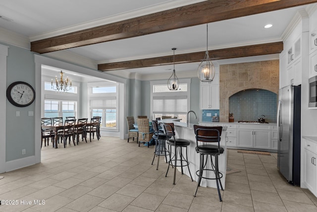 4101 Ocean Dr, Emerald Isle, NC 28594 - kitchen with stainless steel appliances, a chandelier, beamed ceiling, plenty of natural light, and a breakfast bar area