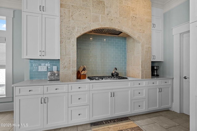 4101 Ocean Dr, Emerald Isle, NC 28594 - kitchen with tasteful backsplash, ornamental molding, light countertops, white cabinets, and stainless steel gas stovetop