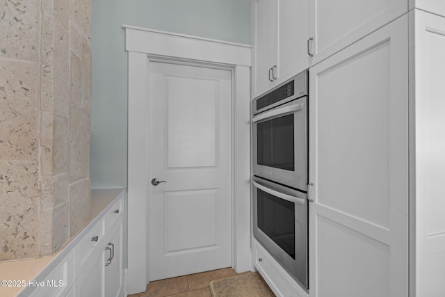 4101 Ocean Dr, Emerald Isle, NC 28594 - kitchen featuring double oven, white cabinetry, light tile patterned floors, and light countertops