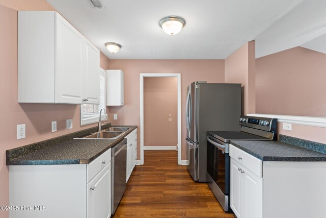 1281 Washington Rd, Southport, NC 28461 - kitchen featuring stainless steel appliances, white cabinetry, dark countertops, and dark wood finished floors
